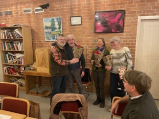 Kent Lang delar ut blommor till Arne, Elin och Inger